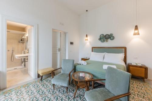 a bedroom with a bed and two chairs and a table at MandorleOlio in Polignano a Mare