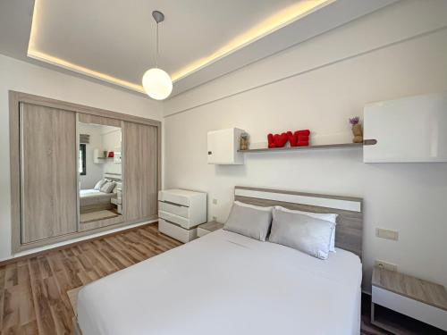 a bedroom with a white bed and a mirror at charming and cozy studio with swimming pool in Marrakesh