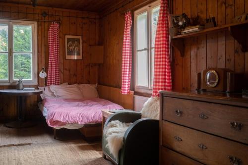 ヴェルケー・カルロヴィツェにあるChata u studánkyのベッドとテーブルと窓のある寝室