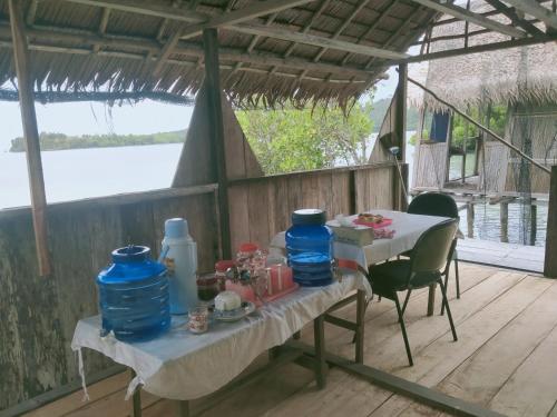 a table with two blue vases on it on a porch at Seawhip Homestay in Minyaifuin