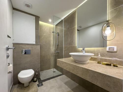 a bathroom with a toilet and a sink and a shower at Poolside Townhome with 2 Masters, a Huge Terrace in El Gouna in Hurghada