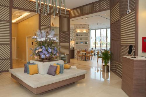 a lobby with a couch with a vase of flowers at Pavilion Hotel Al Jaddaf - Managed by Nooa in Dubai
