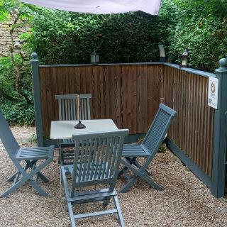 two chairs and a table with an umbrella in a backyard at La Chambre des Buissonnats in Martailly-lès-Brancion