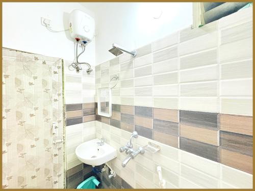 une salle de bain avec lavabo et douche dans l'établissement Baliapand Road NewParwati Palace Inn- #Fully Air Condition with All Luxury Luxuary Rooms #Balcony Free Wifi # Parking & Lift Facilities- Best Luxuary Hotel In Puri, à Purî