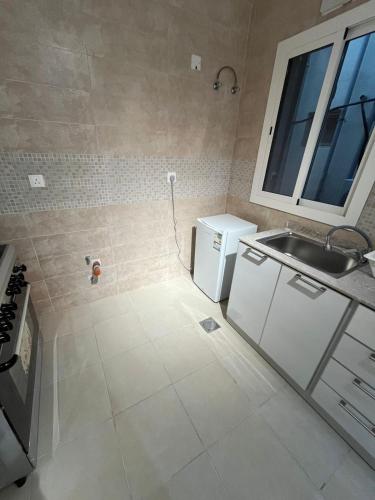 a small kitchen with a sink and a refrigerator at شقة متكاملة بجوار ملعب الجوهرة in Jeddah