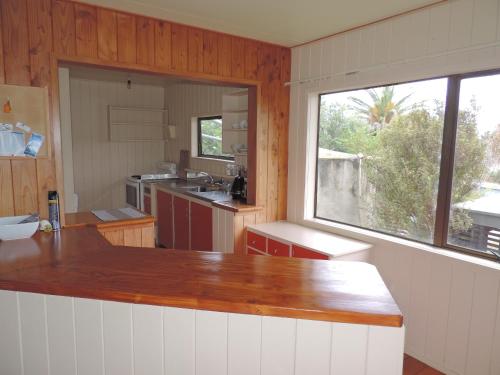 a kitchen with a large window and a counter top at Waiheke Island Tawa Lodge - Adults Only in Oneroa
