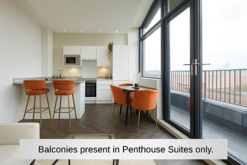 a kitchen with orange chairs and a table at Humber Lofts Apartments in Hull