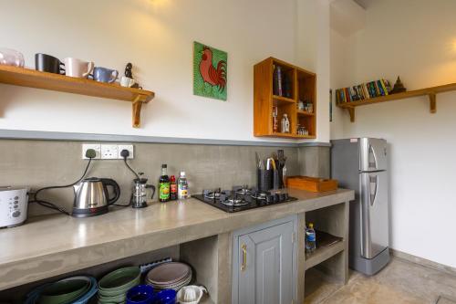 kuchnia z kuchenką i lodówką w obiekcie Old Chilli House w mieście Unawatuna