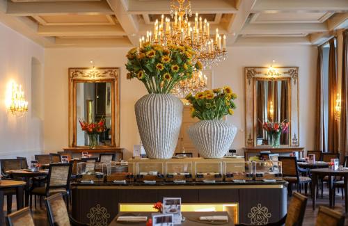 two large vases with flowers on a table in a restaurant at Grand Hotel Karel V in Utrecht