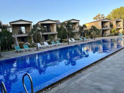 una gran piscina con sillas azules y apartamentos en condominio en Hôtel du parc exotique, en Mbour