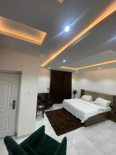 ein Schlafzimmer mit einem Bett und zwei Stühlen darin in der Unterkunft Elite Luxe in Lekki