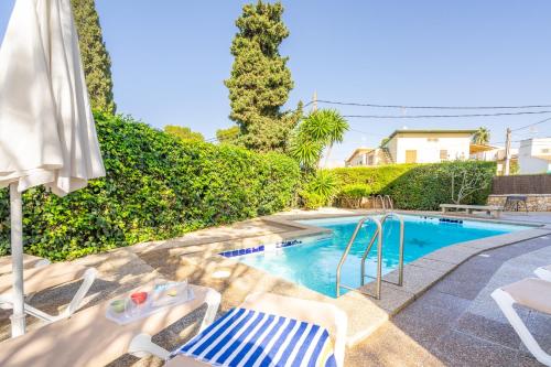 einen Pool mit zwei Gartenstühlen und einem Pool in der Unterkunft Villa Son Veri d'Alt in El Arenal