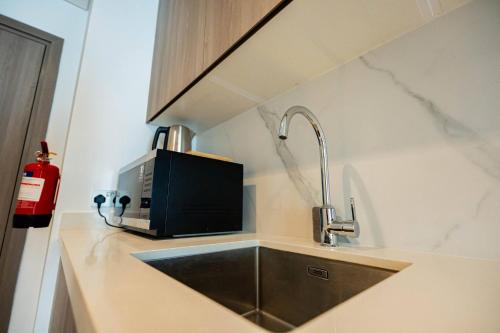 Yas IslandLuxury Yas Golf Stay Near F1 Track的带水槽和微波炉的厨房柜台