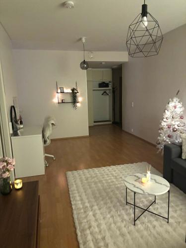 un salon avec un sapin de Noël et une table dans l'établissement Apartment, à Rovaniemi