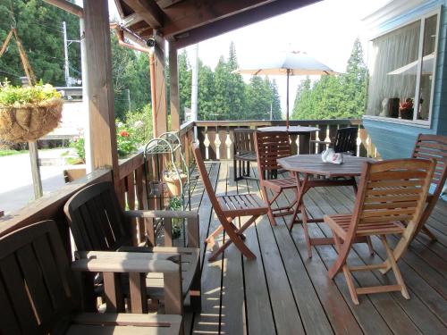 una terraza de madera con mesa y sillas. en Pension Come, en Minami Uonuma