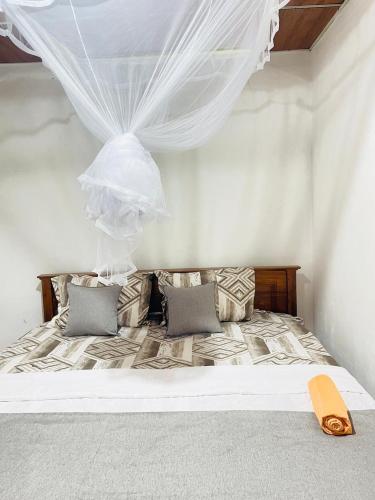 a bedroom with a bed with mosquito nets on it at Dhana Breeze in Weligama