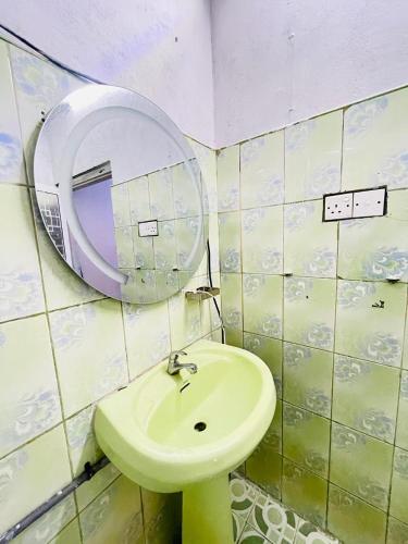 a bathroom with a green sink and a mirror at Dhana Breeze in Weligama