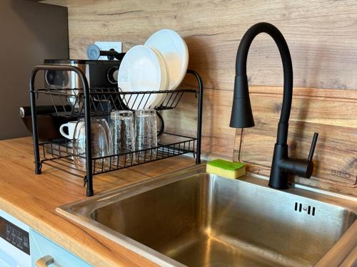 eine Küchenspüle mit einem Abtropfgestell daneben in der Unterkunft SkyWay by NightSpace- Modern City Apartment in Sofia