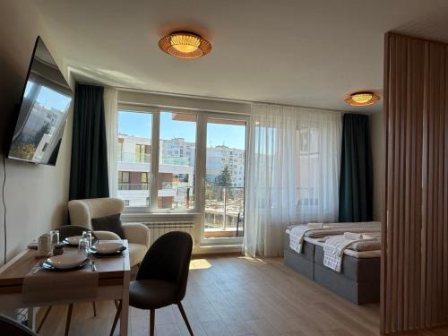 ein Hotelzimmer mit Bett, Tisch und Stühlen in der Unterkunft SkyWay by NightSpace- Modern City Apartment in Sofia