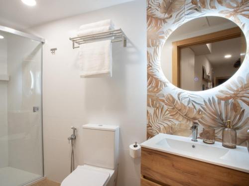 une salle de bain avec toilettes, lavabo et miroir dans l'établissement ITURRIONDO by Urdaibai Experience, à Guernica y Luno