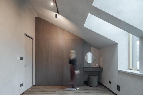 eine Person, die in einem Raum mit einem Spiegel geht in der Unterkunft Imperial Residence - design aparthotel in city center, private parking in Banská Bystrica