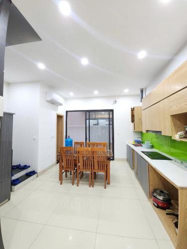 a kitchen with wooden chairs and a table in it at Timi Homestay Near the Wave Park Ocean Park 2 in Hòa Bình