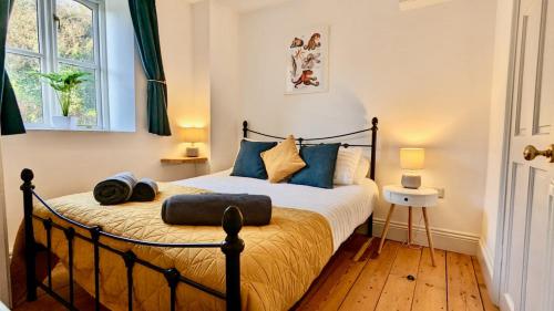 a bedroom with a large bed with blue pillows at The Quaker Hall - Private Deck - Stunning Views in Falmouth