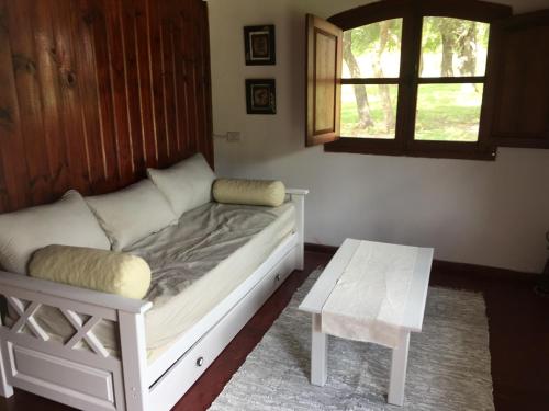 Cama en habitación con mesa y ventana en La casita en la Juni, en San Javier