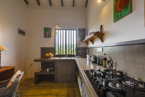een keuken met een fornuis en een aanrechtblad bij Old Chilli House in Unawatuna