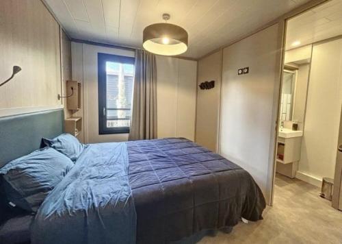 a bedroom with a bed with a blue blanket at Le Cottage de Laura Jullouville 6 pers in Jullouville-les-Pins