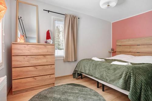 un dormitorio con una cama y un espejo en Villa Lapland Luxe, Private Sauna, Free Wifi, en Rovaniemi