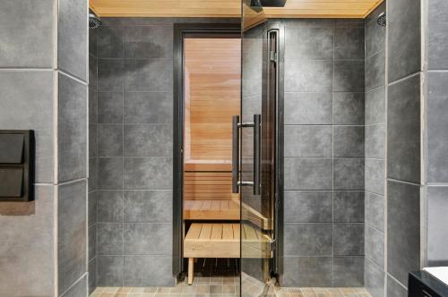 una ducha con puerta de cristal en un baño en Villa Lapland Luxe, Private Sauna, Free Wifi, en Rovaniemi