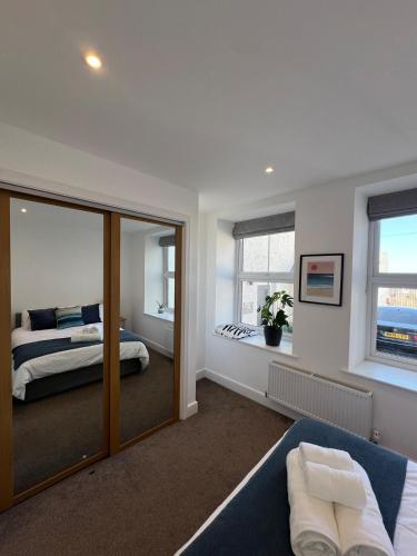 a bedroom with a king sized bed and a mirror at 1 Bed Apartment in Town Centre in Newquay