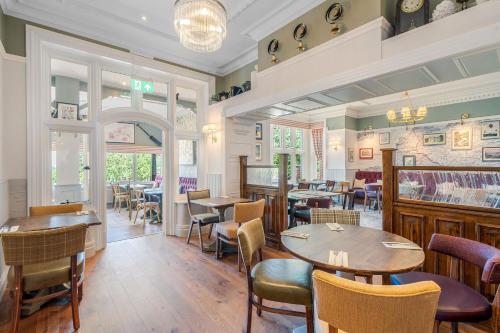 a restaurant with tables and chairs in a room at Sidcot Arms in Winscombe