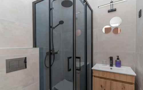 une douche avec une porte vitrée à côté d'un lavabo dans l'établissement Villa Arborea by Villas Guide, à Molunat