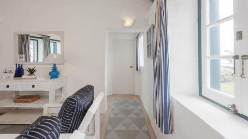 einen Flur mit zwei schwarzen Stühlen und einem Tisch in der Unterkunft Zandtorini Seaside Cottage in Struisbaai