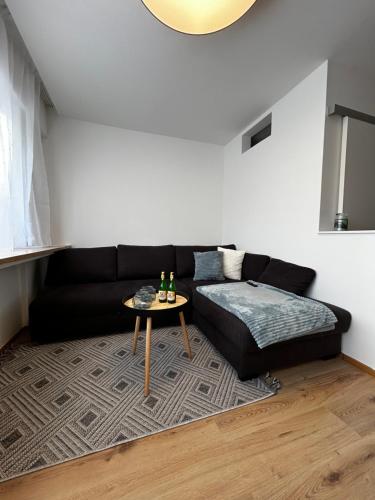 un salon avec un canapé noir et une table dans l'établissement Apartment Alpenglanz, à Bad Mitterndorf