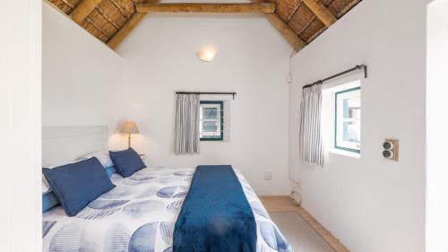 ein Schlafzimmer mit einem großen Bett in einem Zimmer in der Unterkunft Zandtorini Seaside Cottage in Struisbaai