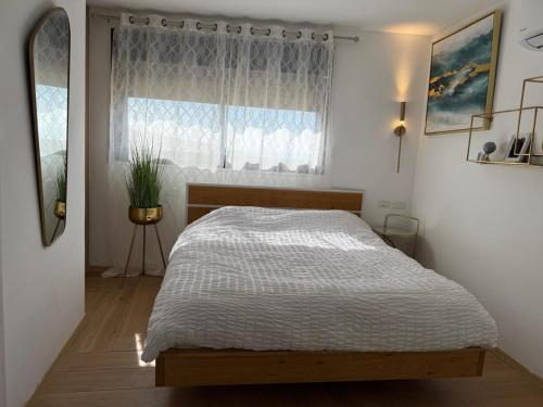 Un dormitorio con una cama y una ventana en גרין פארק - קוטג' מהמם עם בריכה מחוממת וג'קוזי בעין קנייא, en Ein Kinya