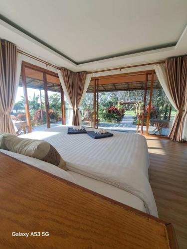 a large white bed in a room with windows at Bulan Villa Koh Yao Noi in Ban Laem Sai