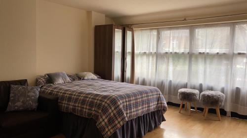 a bedroom with a bed with a plaid blanket and a window at 37chats studio in London
