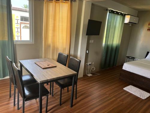 a room with a table and chairs and a bed at MJay's Studio in Paix Bouche