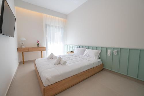 a bedroom with a large bed with white sheets at Michail Old Harbour Residence in Kos