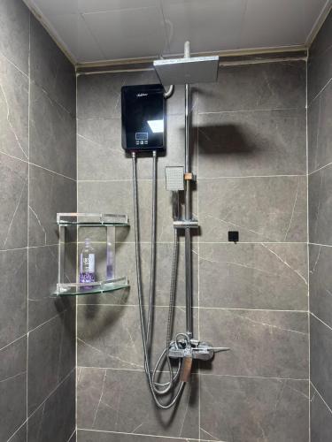 a shower with a television in a bathroom at Enzi Apartment Block A in Nairobi