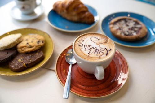 un tavolo con piatti di pasticcini e una tazza di caffè di Habitat Monti a Roma