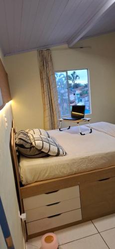 a bedroom with a bed with a laptop on it at Vilars154 - Cavaleiros e Lagoa in Macaé