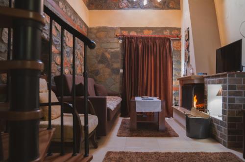 a living room with a fireplace and a couch at ΞΕΝΩΝΑΣ ΘΕΑ in Palaios Agios Athanasios
