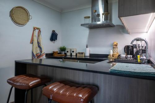 a kitchen with a counter and two bar stools at Apart Hotel Dresden in Santiago