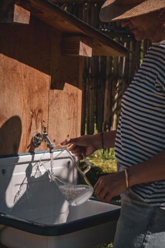 a woman is washing a sink in a table at Pension Steinkogel in Sankt Leonhard im Pitztal
