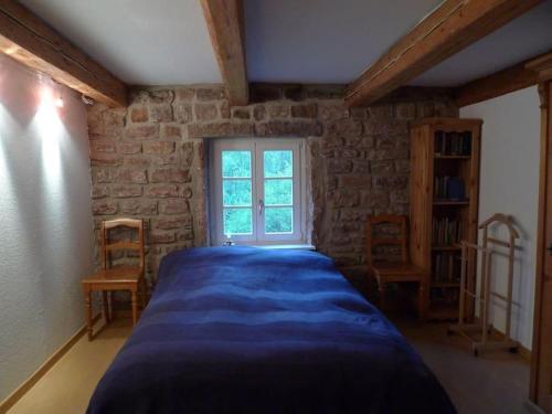 ein Schlafzimmer mit einem blauen Bett in einem Zimmer mit einem Fenster in der Unterkunft Ferienhaus In Walscheid Mit Terrasse, Grill in Walscheid